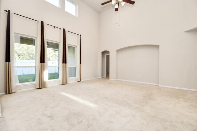 14542 Northern Mountain Ct, Houston, TX 77090 - carpeted spare room with arched walkways, a ceiling fan, a towering ceiling, and baseboards