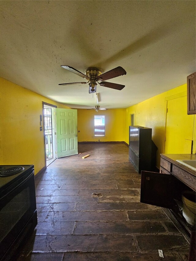 3131 Vintage St, Houston, TX 77026 - unfurnished living room featuring a ceiling fan, baseboards, dark wood-style floors, and a sink