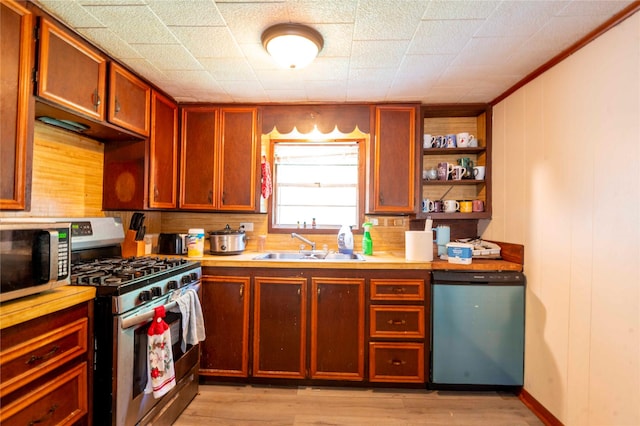 522 Price Dr, San Augustine, TX 75972 - kitchen with stainless steel appliances, a sink, open shelves, light wood-type flooring, and light countertops