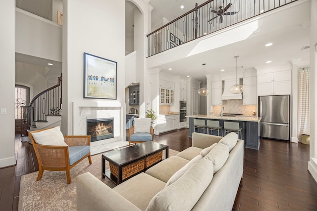 1211 Chamboard Ln, Houston, TX 77018 - living room featuring a towering ceiling, dark wood-type flooring, stairway, a fireplace, and recessed lighting