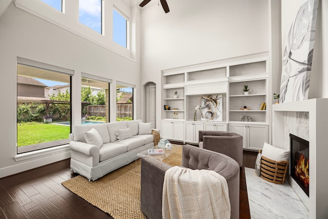 1211 Chamboard Ln, Houston, TX 77018 - living room with a high ceiling, a ceiling fan, a glass covered fireplace, wood finished floors, and built in shelves