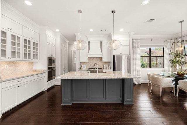 1211 Chamboard Ln, Houston, TX 77018 - kitchen with stainless steel appliances, custom exhaust hood, white cabinets, glass insert cabinets, and dark wood finished floors