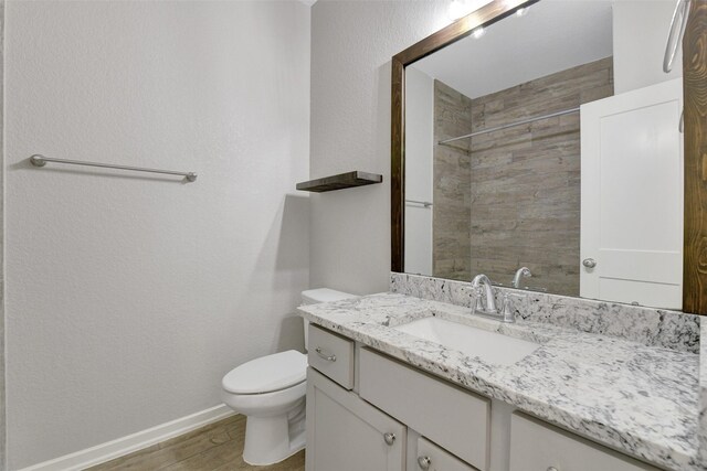 12407 Palo Acebo Ln, Humble, TX 77346 - full bathroom featuring wood finished floors, baseboards, toilet, vanity, and a tile shower