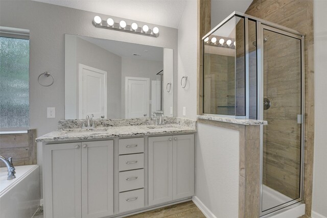 12407 Palo Acebo Ln, Humble, TX 77346 - full bath with a shower stall, double vanity, a garden tub, and wood finished floors