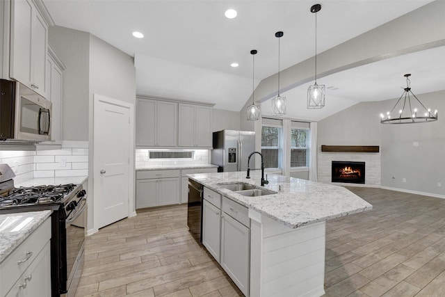 12407 Palo Acebo Ln, Humble, TX 77346 - kitchen featuring appliances with stainless steel finishes, a sink, lofted ceiling, light wood-type flooring, and decorative backsplash