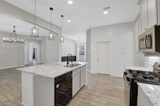 12407 Palo Acebo Ln, Humble, TX 77346 - kitchen featuring range with gas stovetop, dishwasher, a sink, stainless steel microwave, and light wood-type flooring