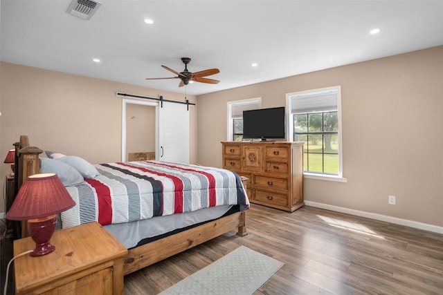 416 State Highway 21 E, Crockett, TX 75835 - bedroom with a barn door, baseboards, wood finished floors, recessed lighting, and ceiling fan
