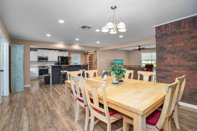 416 State Highway 21 E, Crockett, TX 75835 - dining space with a barn door, a ceiling fan, light wood-style flooring, a chandelier, and baseboards