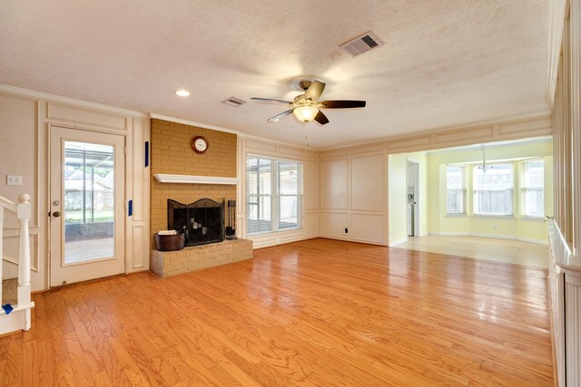 333 Banyan Dr, Lake Jackson, TX 77566 - unfurnished living room featuring ornamental molding, ceiling fan, light wood-style floors, a decorative wall, and a fireplace