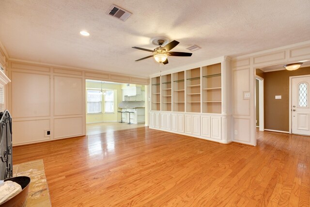 333 Banyan Dr, Lake Jackson, TX 77566 - unfurnished living room featuring a decorative wall, a ceiling fan, crown molding, a textured ceiling, and light wood-style floors