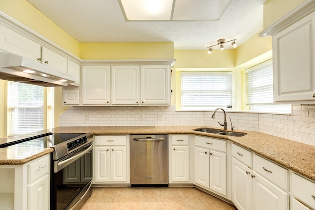 333 Banyan Dr, Lake Jackson, TX 77566 - kitchen featuring stainless steel appliances, a sink, under cabinet range hood, tasteful backsplash, and plenty of natural light