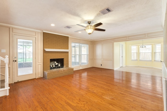 333 Banyan Dr, Lake Jackson, TX 77566 - unfurnished living room with a decorative wall, ornamental molding, a ceiling fan, a fireplace, and light wood-style flooring