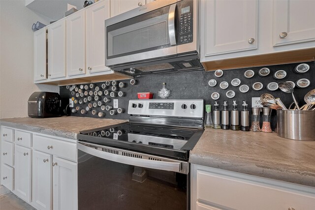 4515 Briar Hollow Pl Unit 307, Houston, TX 77027 - kitchen with appliances with stainless steel finishes, white cabinetry, decorative backsplash, and light countertops