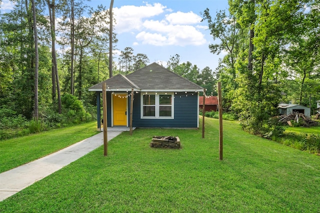 15229 Travis Ln, Willis, TX 77378 - view of front of house with a front yard, an outdoor fire pit, and roof with shingles