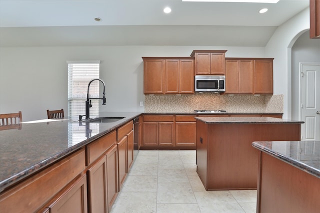 10014 Mahaffey Rd, Tomball, TX 77375 - kitchen with appliances with stainless steel finishes, dark stone counters, backsplash, brown cabinets, and recessed lighting