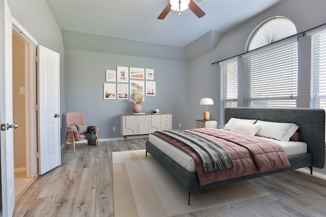 10014 Mahaffey Rd, Tomball, TX 77375 - bedroom with light wood-type flooring, multiple windows, vaulted ceiling, a ceiling fan, and baseboards