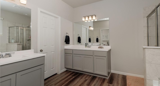 10137 Whooping Crane Way, Magnolia, TX 77354 - bathroom featuring a stall shower, wood finished floors, two vanities, and baseboards