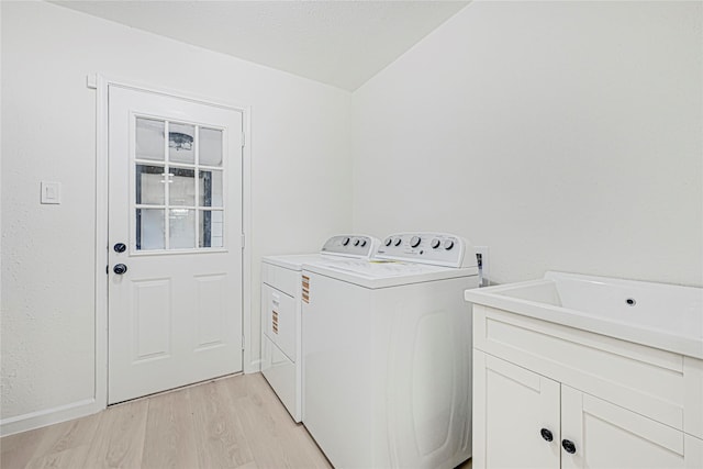 5815 Old Lodge Dr, Houston, TX 77066 - clothes washing area with independent washer and dryer, light wood-type flooring, and cabinet space