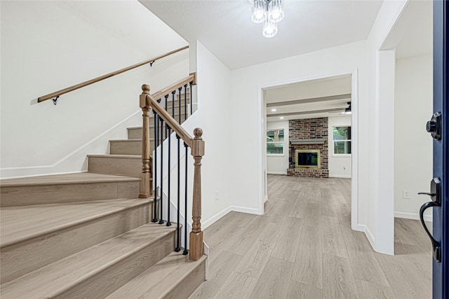 5815 Old Lodge Dr, Houston, TX 77066 - foyer entrance featuring wood finished floors, stairway, a brick fireplace, and baseboards