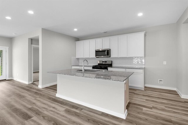 311 Emma St, Angleton, TX 77515 - kitchen with stainless steel appliances, a sink, light wood-style floors, baseboards, and recessed lighting