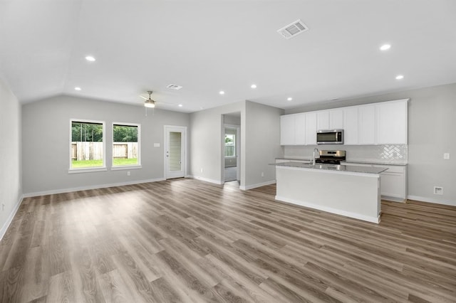 311 Emma St, Angleton, TX 77515 - kitchen with appliances with stainless steel finishes, open floor plan, an island with sink, white cabinets, and recessed lighting