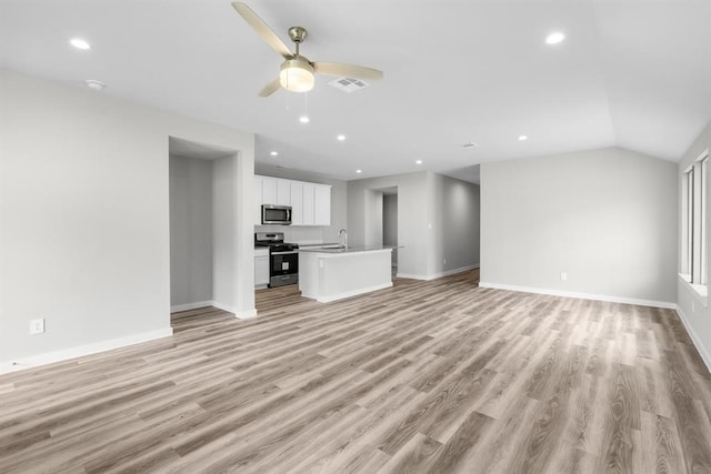 311 Emma St, Angleton, TX 77515 - unfurnished living room with light wood finished floors, baseboards, ceiling fan, recessed lighting, and lofted ceiling