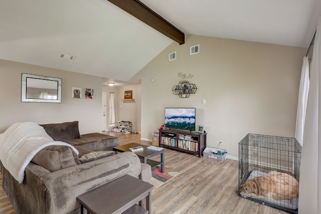 living room with beamed ceiling, light wood finished floors, baseboards, and high vaulted ceiling