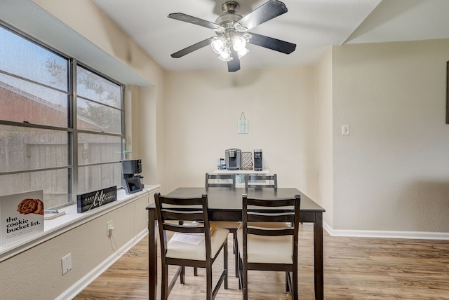 dining space with light wood-type flooring, baseboards, and a ceiling fan