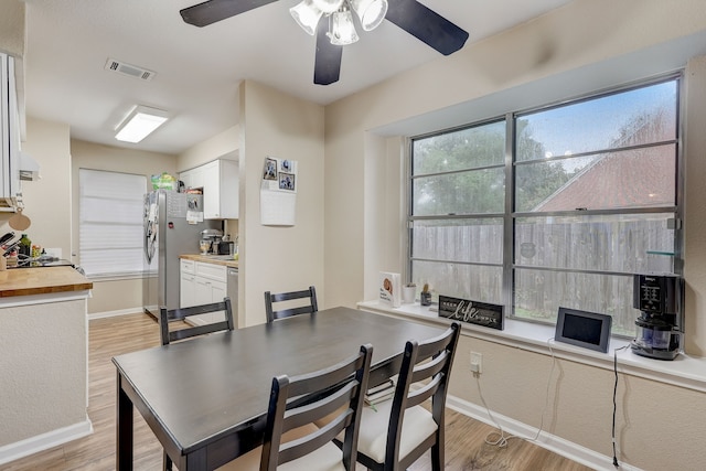 dining space featuring light wood-style floors, baseboards, and ceiling fan
