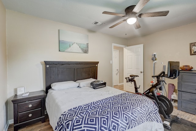 bedroom with wood finished floors, baseboards, and a ceiling fan