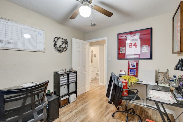 office with light wood-type flooring and ceiling fan