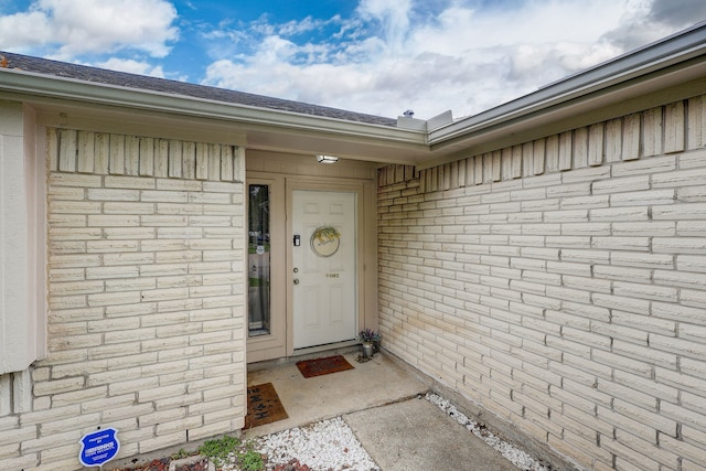 entrance to property featuring brick siding