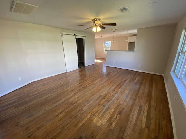 7209 La Salette St, Houston, TX 77021 - spare room with a barn door, ceiling fan, dark wood-style floors, and baseboards