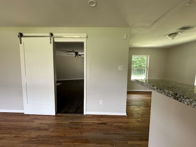 7209 La Salette St, Houston, TX 77021 - unfurnished bedroom featuring dark wood-type flooring, baseboards, a barn door, and a closet