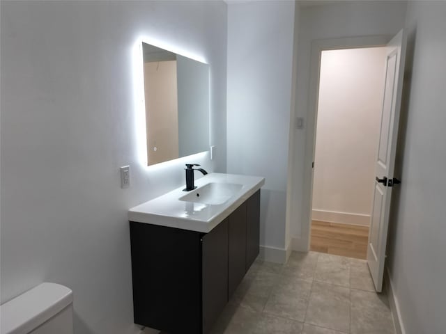 2225 W Clare St, Deer Park, TX 77536 - half bathroom with vanity, toilet, baseboards, and tile patterned flooring