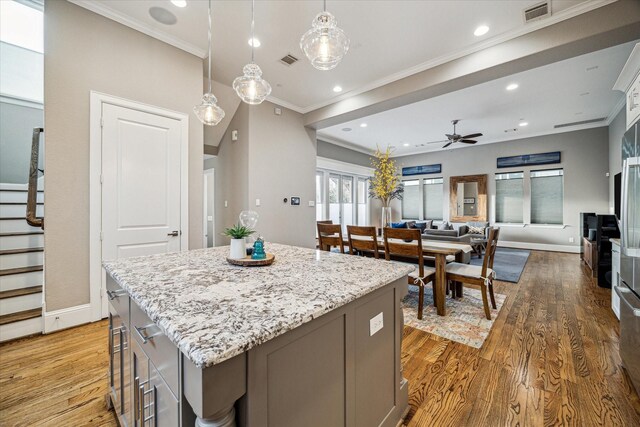 216 W Drew St, Houston, TX 77006 - kitchen featuring ceiling fan, a kitchen island, baseboards, light wood-type flooring, and ornamental molding