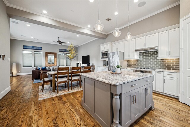 216 W Drew St, Houston, TX 77006 - kitchen with gray cabinetry, wood finished floors, stainless steel appliances, a ceiling fan, and backsplash