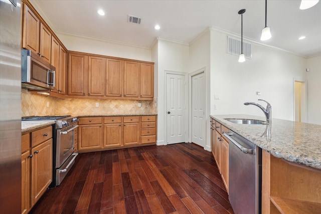 415 Tuam St, Houston, TX 77006 - kitchen with appliances with stainless steel finishes, a sink, ornamental molding, brown cabinets, and dark wood-type flooring