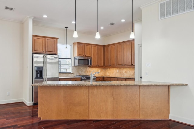 415 Tuam St, Houston, TX 77006 - kitchen with appliances with stainless steel finishes, a sink, light stone counters, dark wood-style floors, and ornamental molding