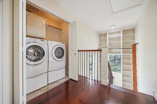 415 Tuam St, Houston, TX 77006 - washroom featuring separate washer and dryer, dark wood finished floors, and cabinet space