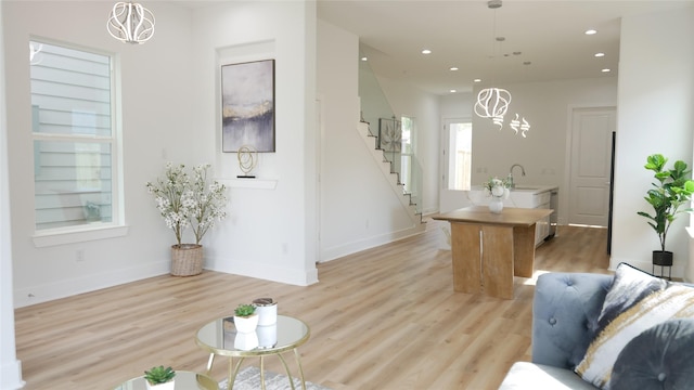 7805 Avenue Ave E, Houston, TX 77012 - living room featuring a chandelier, stairway, light wood finished floors, and recessed lighting