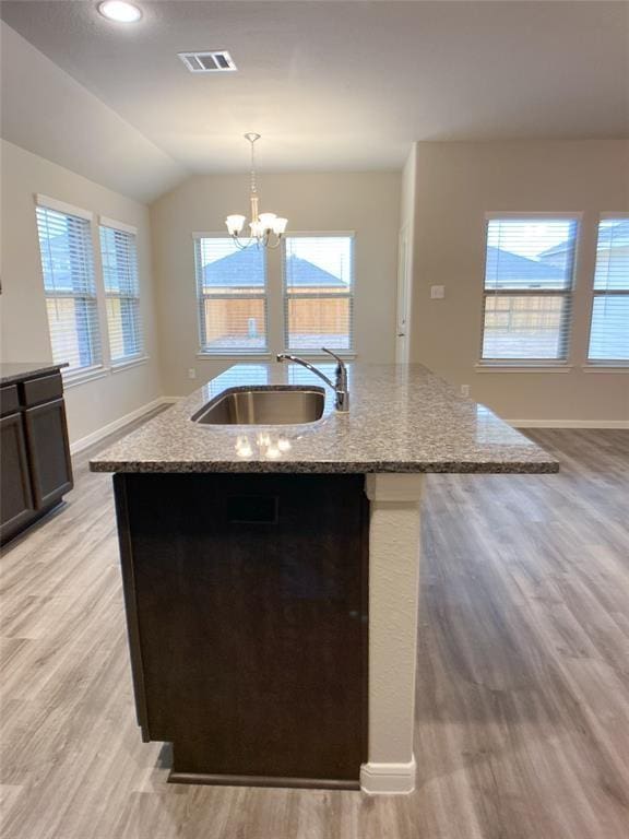 27315 Blue Pool Dr, Katy, TX 77493 - kitchen featuring a sink, light wood finished floors, an island with sink, a chandelier, and light stone counters