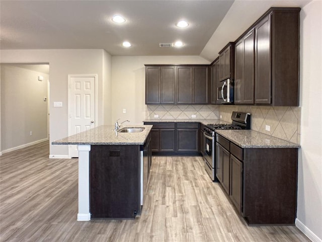 27315 Blue Pool Dr, Katy, TX 77493 - kitchen with appliances with stainless steel finishes, a sink, light stone countertops, light wood-type flooring, and recessed lighting