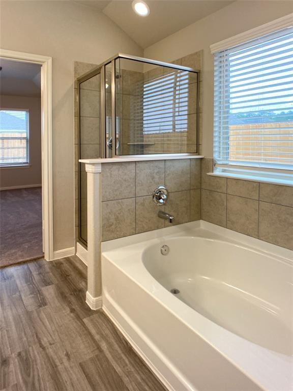 27315 Blue Pool Dr, Katy, TX 77493 - bathroom featuring wood finished floors, a garden tub, a stall shower, lofted ceiling, and baseboards