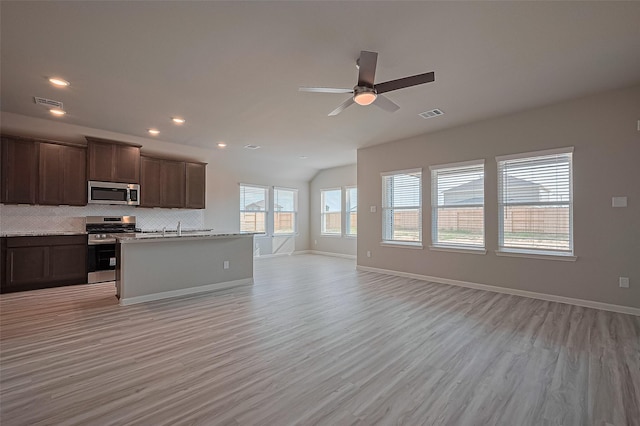 27315 Blue Pool Dr, Katy, TX 77493 - kitchen with stainless steel appliances, open floor plan, light wood-style floors, backsplash, and vaulted ceiling