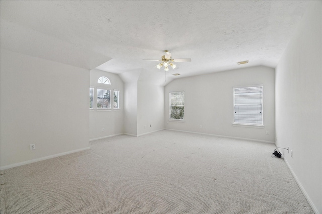 5111 Maple Hill Trl, Houston, TX 77345 - spare room featuring a ceiling fan, vaulted ceiling, light carpet, baseboards, and a textured ceiling