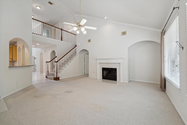 5111 Maple Hill Trl, Houston, TX 77345 - unfurnished living room with ceiling fan, a fireplace, carpet flooring, arched walkways, and high vaulted ceiling