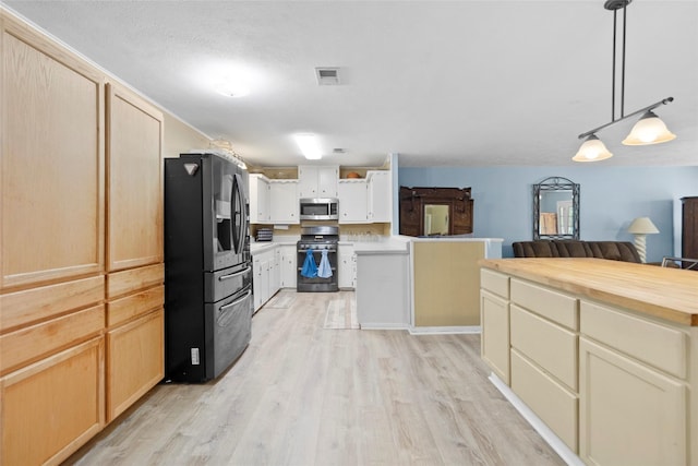 4420 Shady Ln, Huntsville, TX 77320 - kitchen with appliances with stainless steel finishes, light wood-type flooring, decorative light fixtures, open floor plan, and wood counters