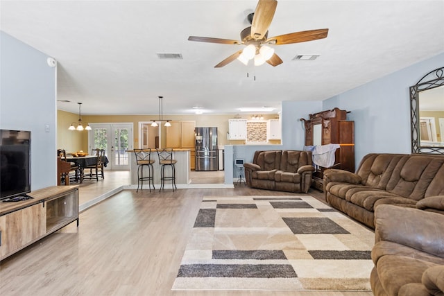 4420 Shady Ln, Huntsville, TX 77320 - living room with light wood finished floors, french doors, and a ceiling fan