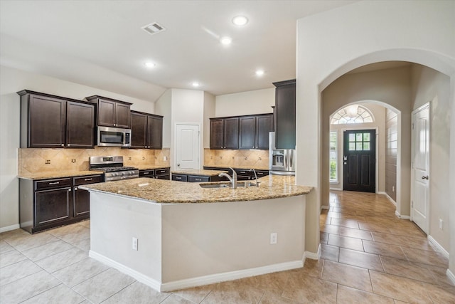 5332 Pointe Spring Xing, Spring, TX 77389 - kitchen featuring appliances with stainless steel finishes, a sink, light stone countertops, dark brown cabinetry, and recessed lighting